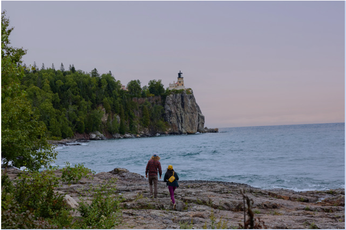 Visitors explore the rocky shoreline below Split Rock Lighthouse State Park on Minnesota’s North Shore of Lake Superior, a region known for its rugged beauty and iconic views.